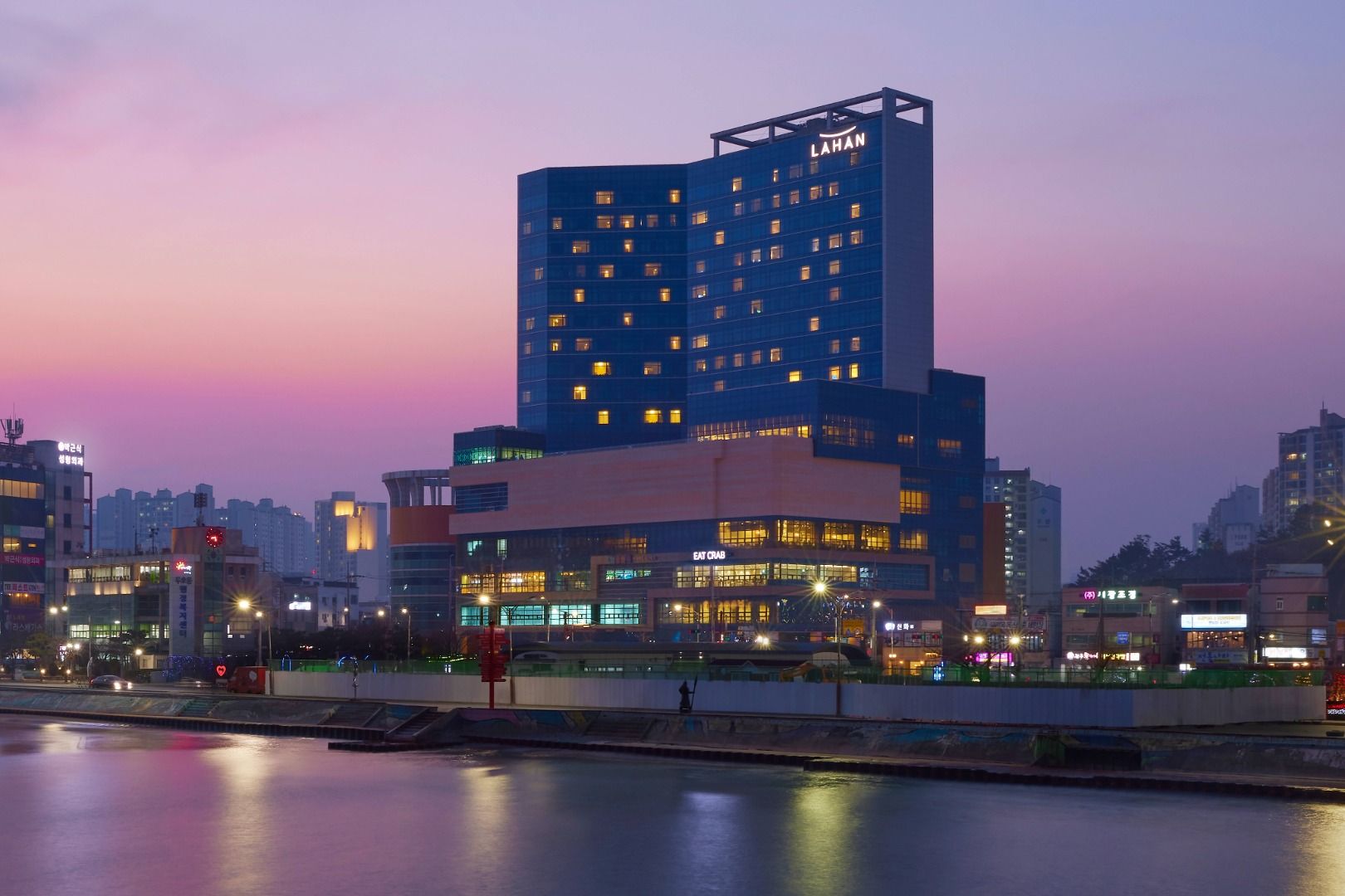 Exterior of LAHAN HOTEL Pohang tower at dusk, seen across the water near Yeongildae Beach